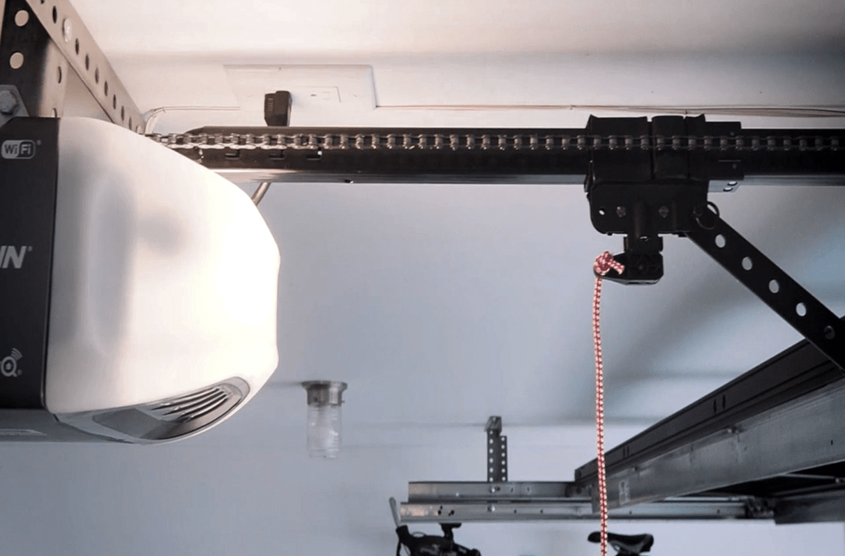 Rail et rouleaux d'une porte de garage qu'on inspecte pour un bruit